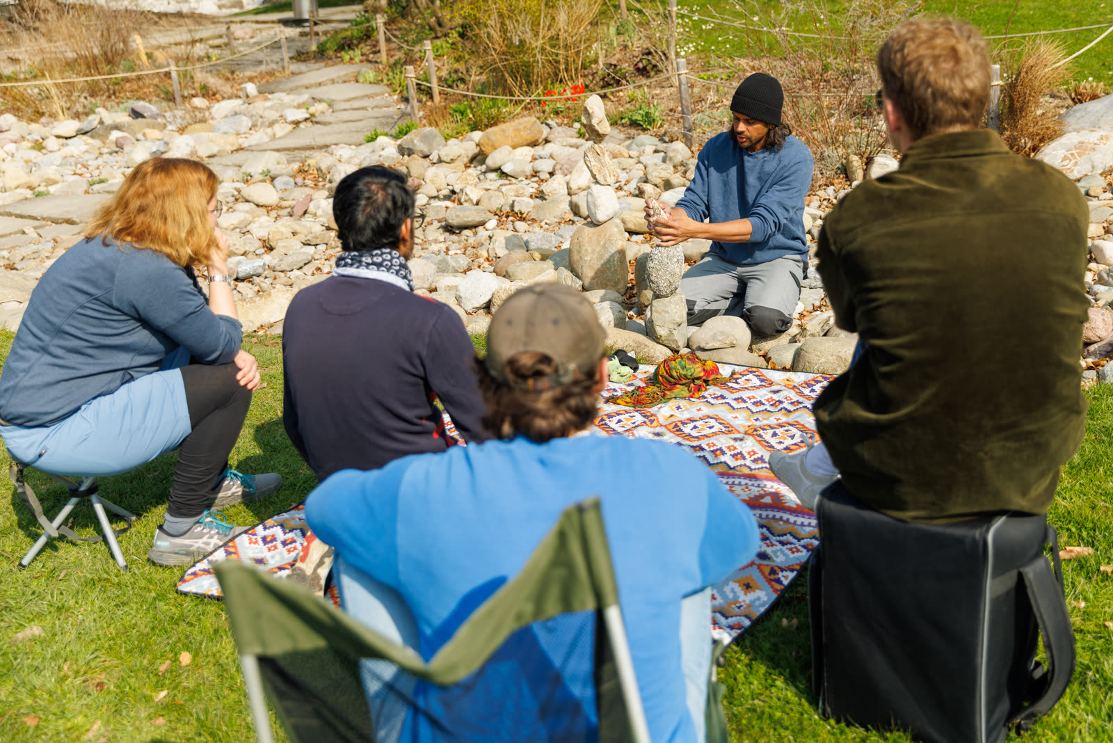 Greg demonstrating a stone balance to a seated workshop group